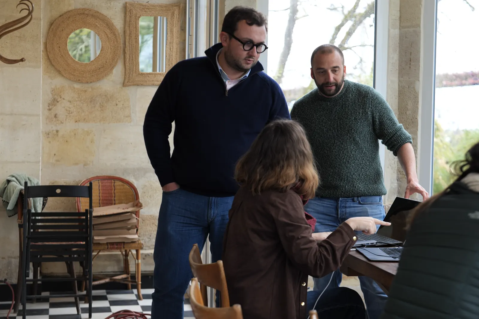 Deux formateurs accompagnent une participante sur son ordinateur
